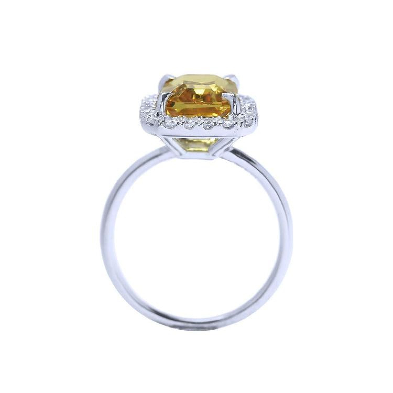 Emerald cut 4.59 ct yellow sapphire ring with diamond halo in 14K white gold.