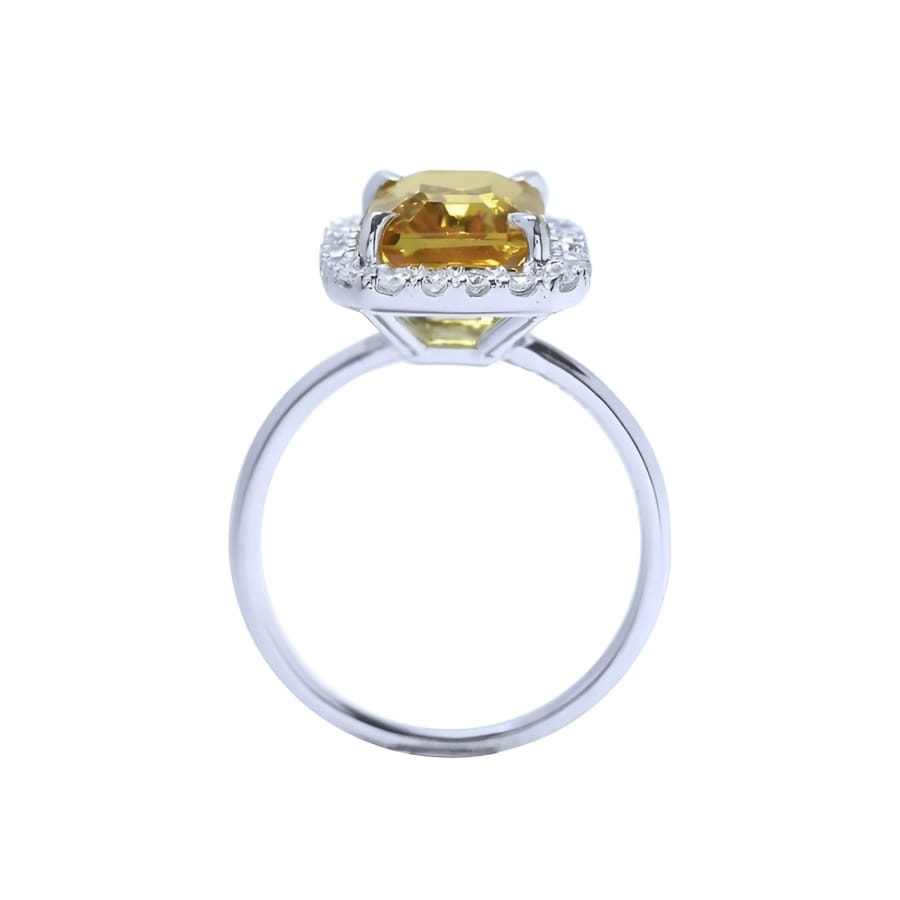 Emerald cut 4.59 ct yellow sapphire ring with diamond halo in 14K white gold.