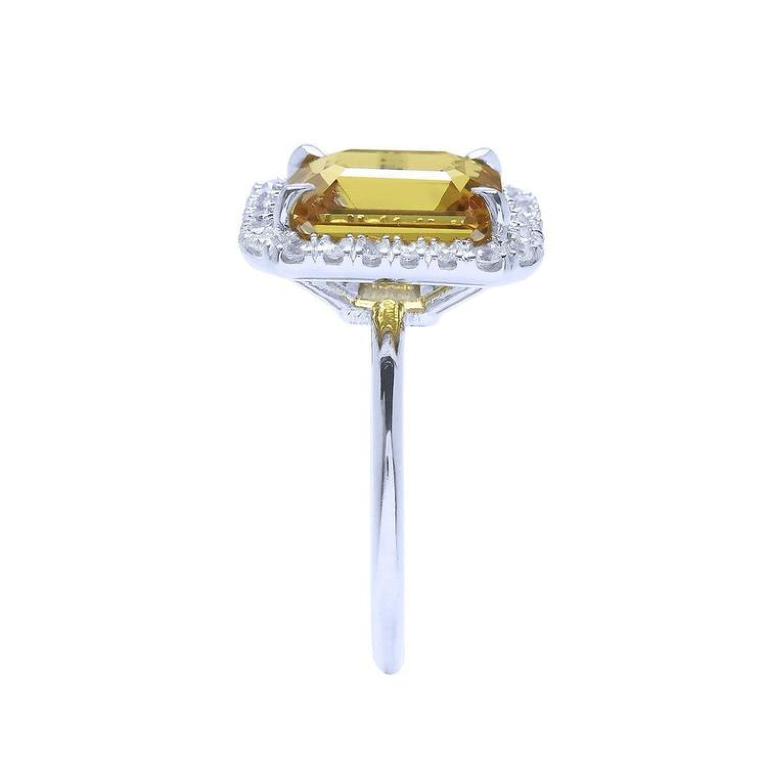 Emerald cut yellow sapphire ring with diamond halo in 14K white gold.