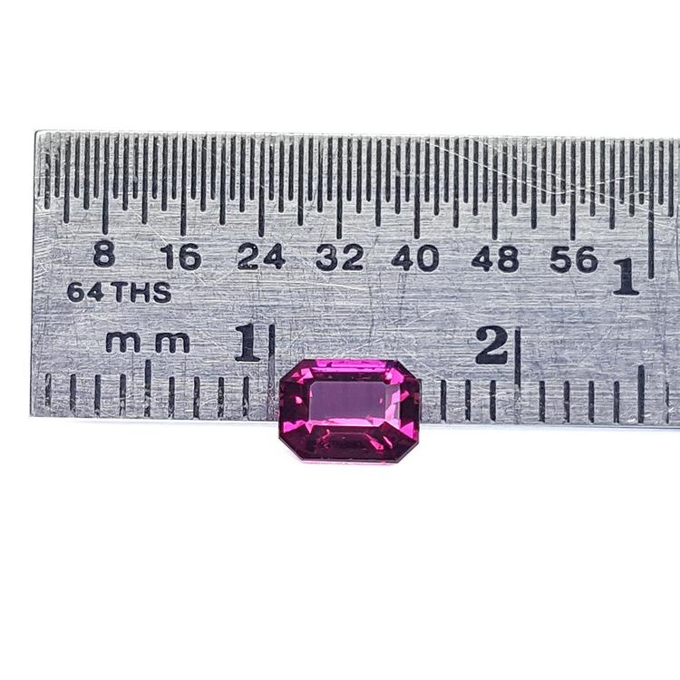 Certified untreated loose natural ruby emerald-cut, front side table and crown visibles on a ruler for scale