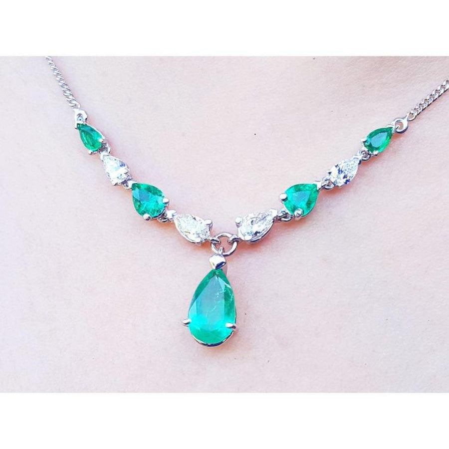 14k white gold necklace with pear-shaped emeralds and diamonds, featuring a large emerald drop pendant.