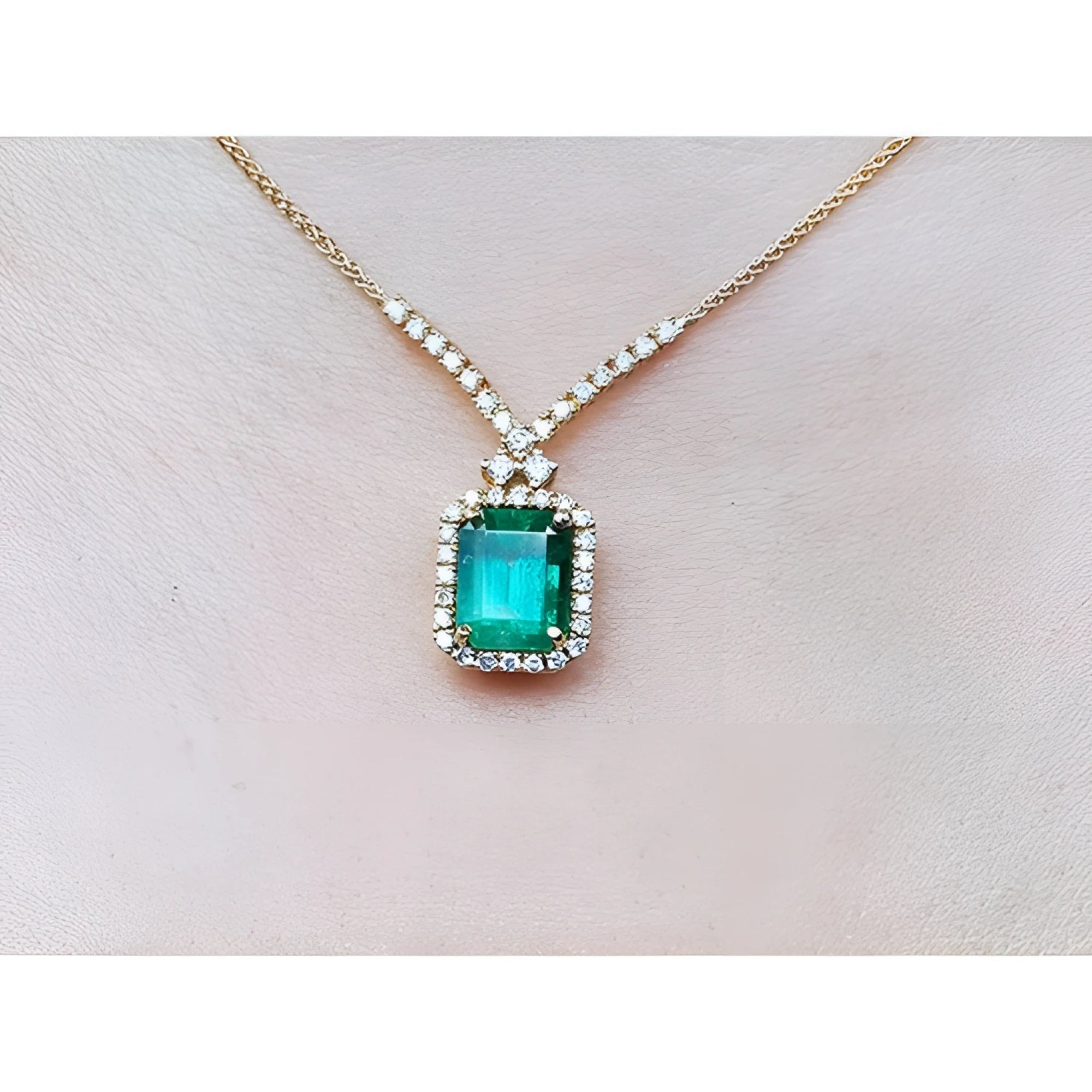 Emerald necklace with halo natural diamonds on a 14K yellow gold chain.
