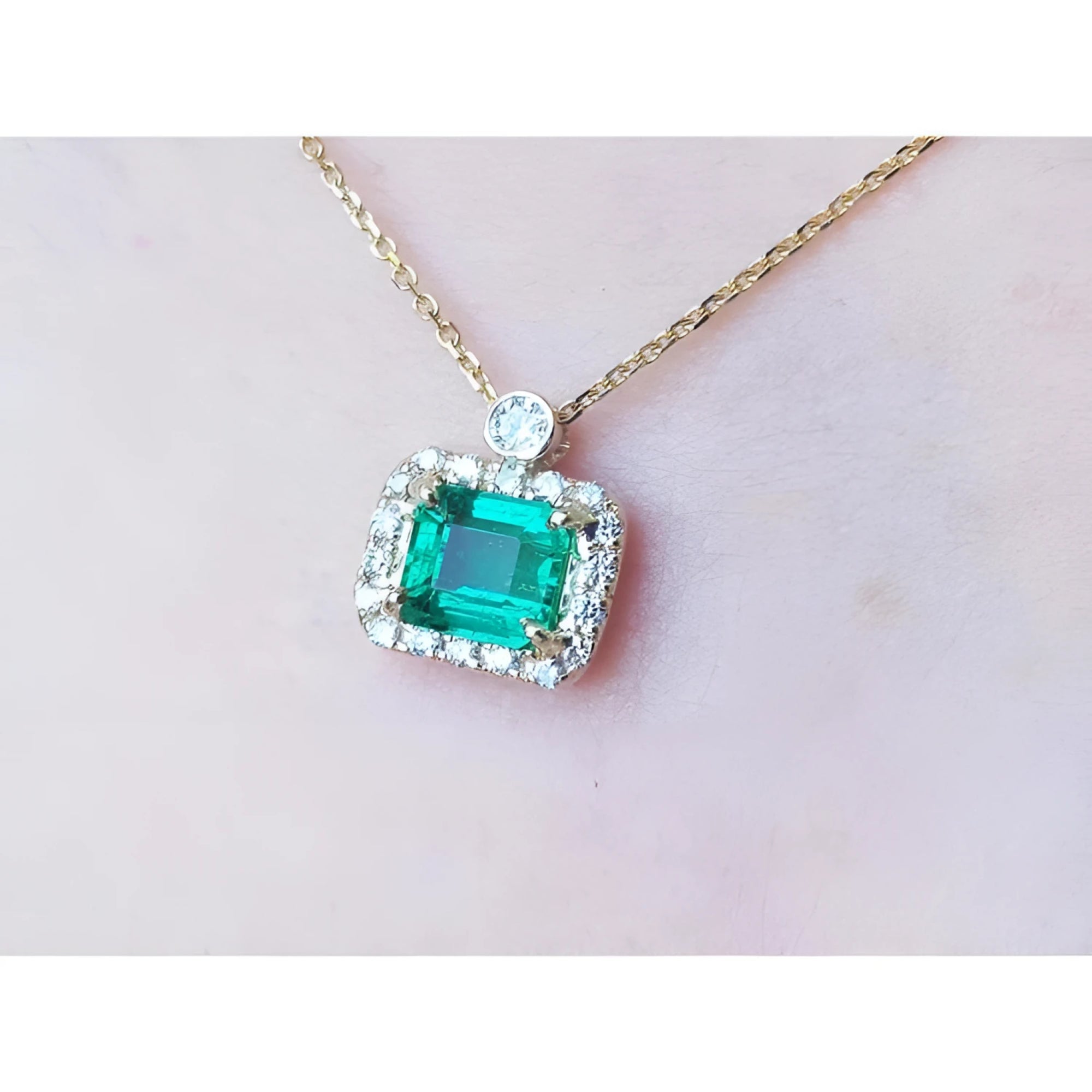 1.31 ct emerald-cut Muzo Colombian emerald necklace with diamonds in 14K yellow gold.