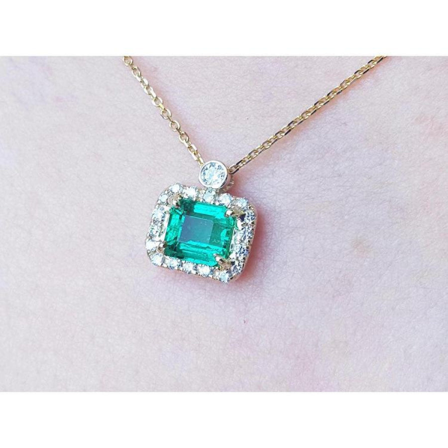 1.31 ct emerald-cut Muzo Colombian emerald necklace with diamonds in 14K yellow gold.