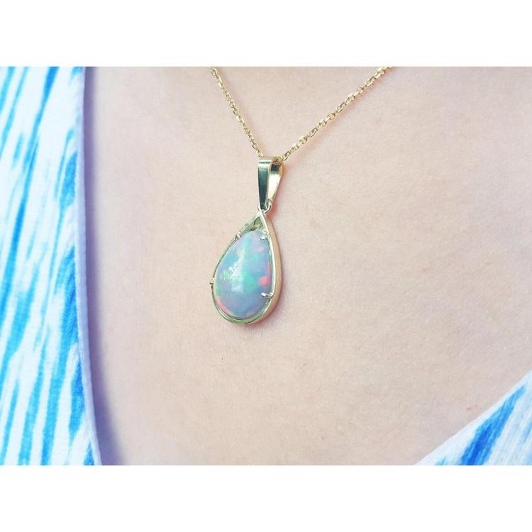 Pear-shaped Ethiopian Welo opal pendant in 14K yellow gold, showing fire red-orange and rainbow colors.