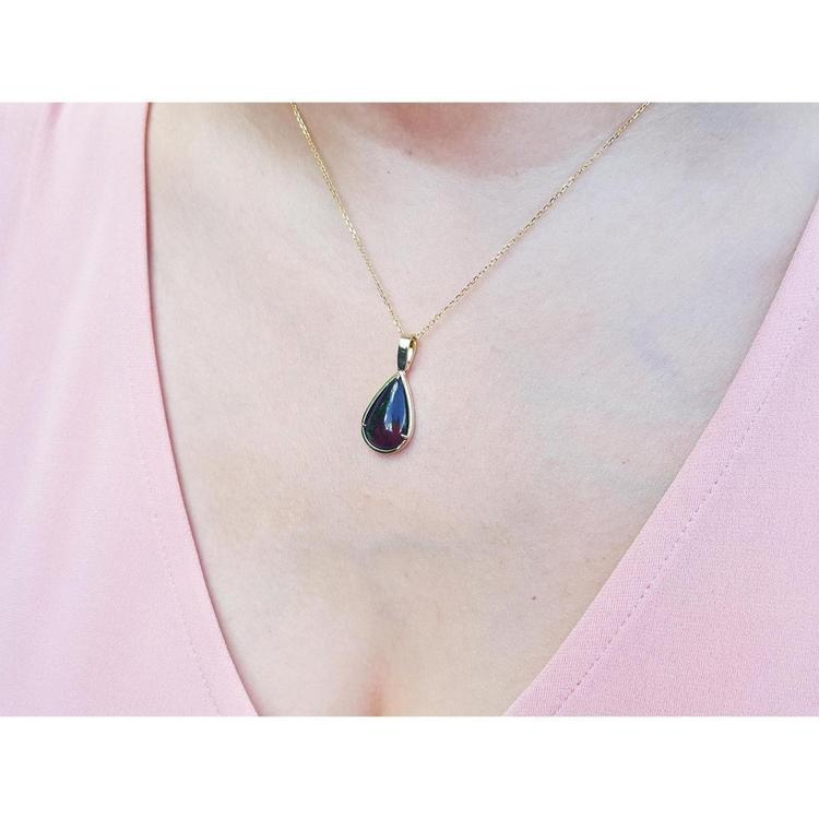 Welo black opal teardrop pendant with red-orange and blue-green flashes on a 14K yellow gold chain.