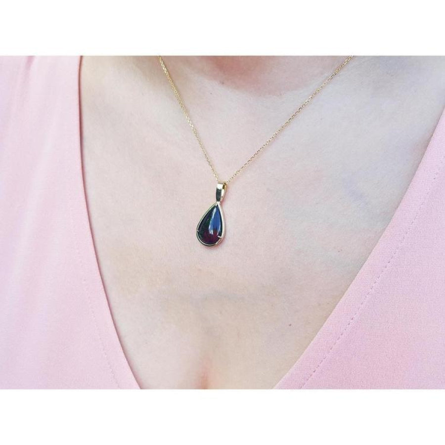 Welo black opal teardrop pendant with red-orange and blue-green flashes on a 14K yellow gold chain.