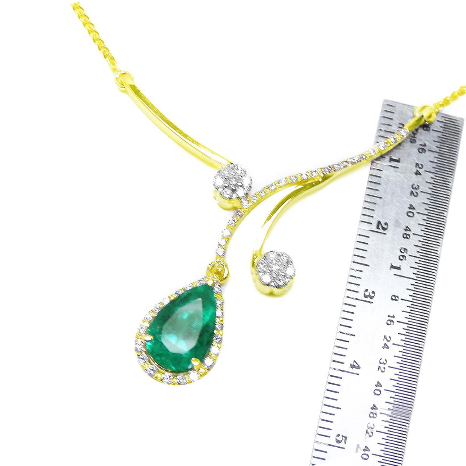 18K yellow gold necklace with a pear-shaped Colombian emerald and diamond clusters, shown with a ruler.