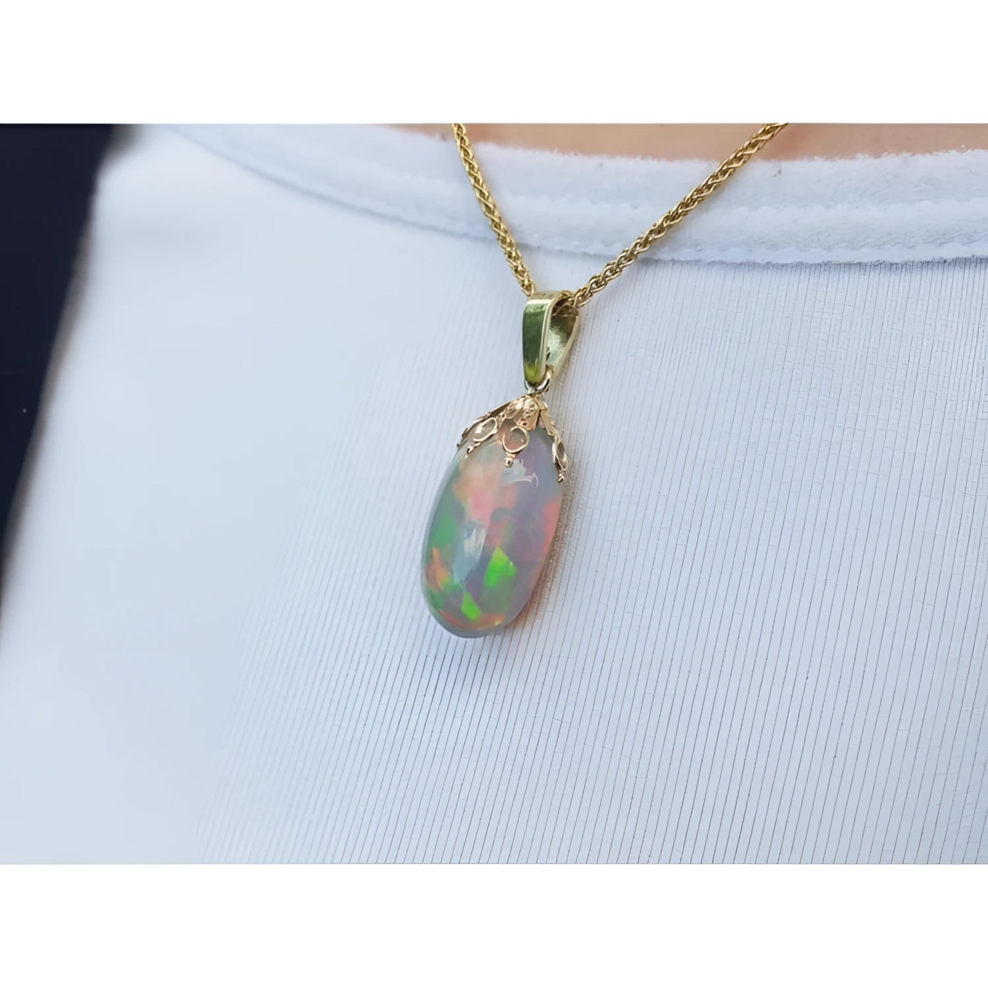 Ethiopian Welo opal pendant with red fire, set in 14k yellow gold on a chain.