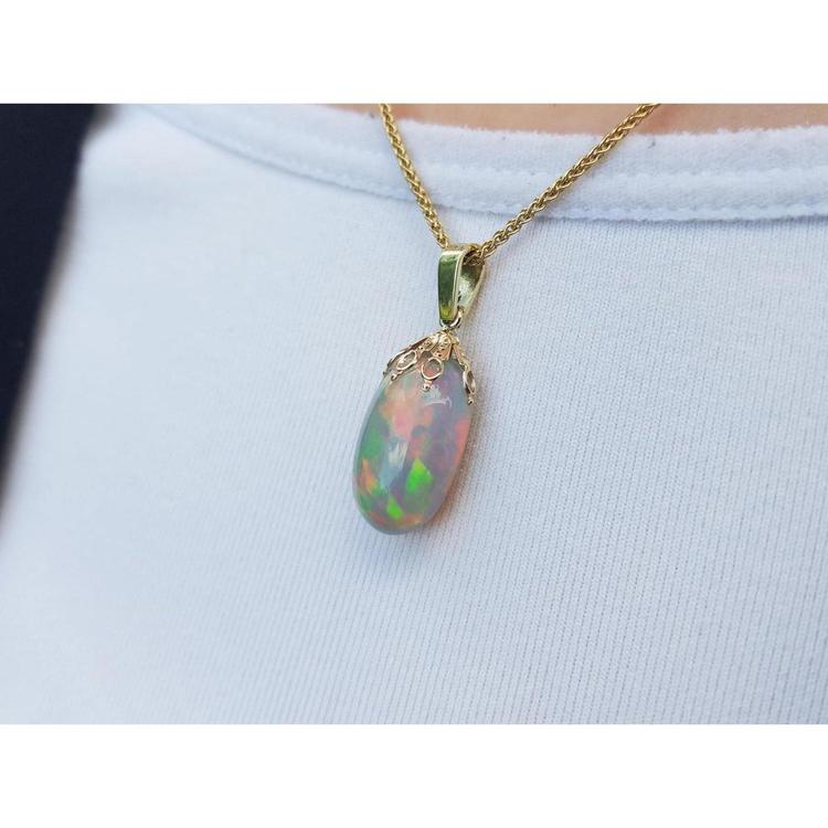 Ethiopian Welo opal pendant with red fire, set in 14k yellow gold on a chain.