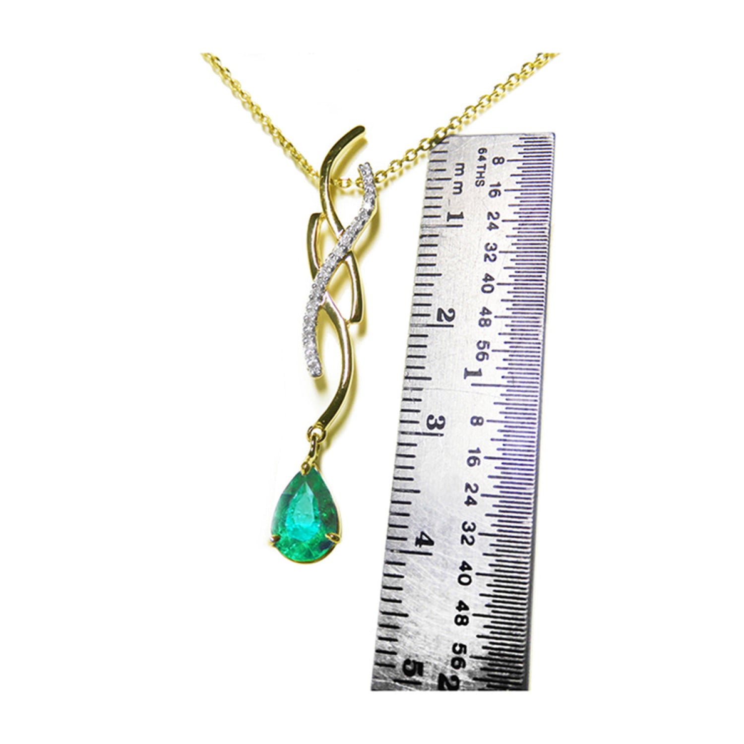 14K yellow gold twisted slider necklace with a pear-shaped emerald pendant and diamond accents, shown with a ruler.