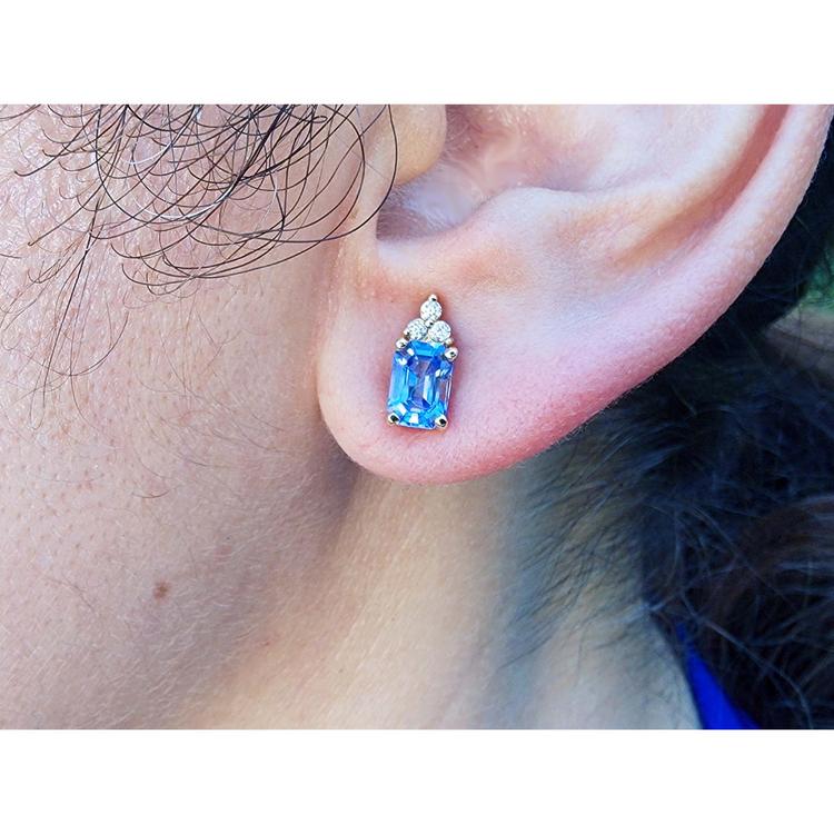 Close-up of an ear wearing a blue natural sapphire and diamonds earring.