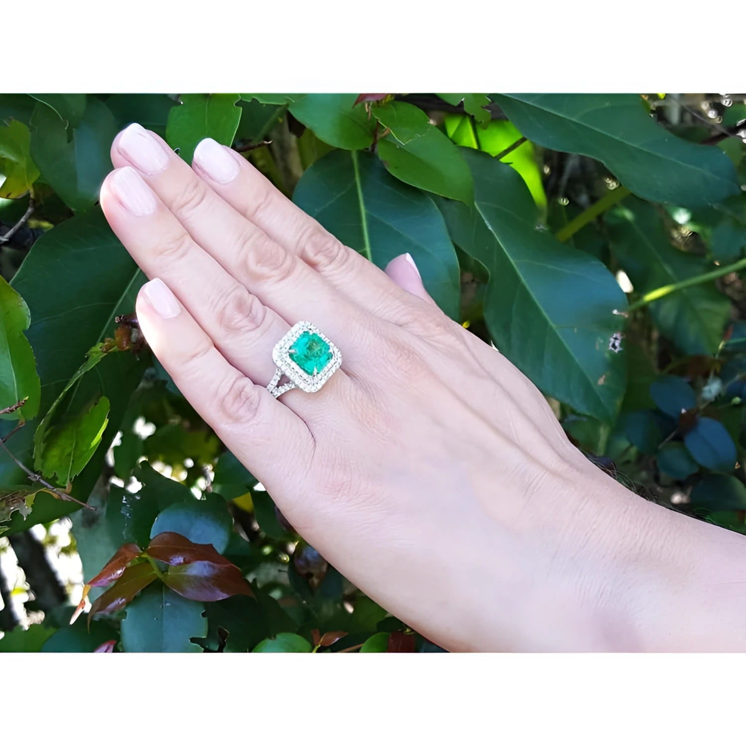 4.14 ct GIA-certified F1 Colombian emerald ring with diamonds in 14K white gold on a hand.