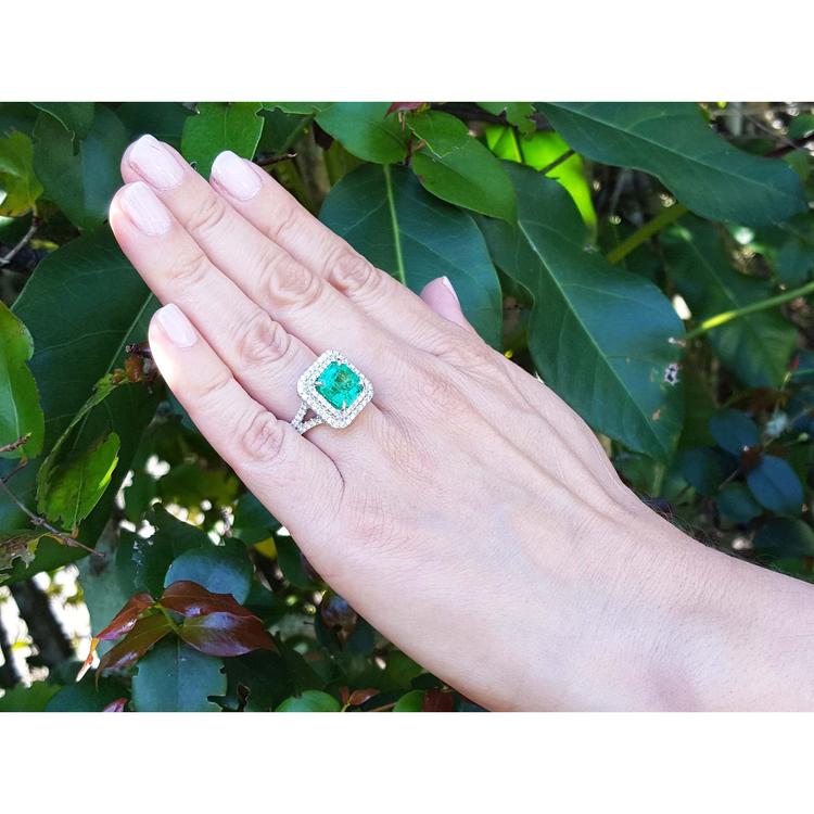 4.14 ct GIA-certified F1 Colombian emerald ring with diamonds in 14K white gold on a hand.