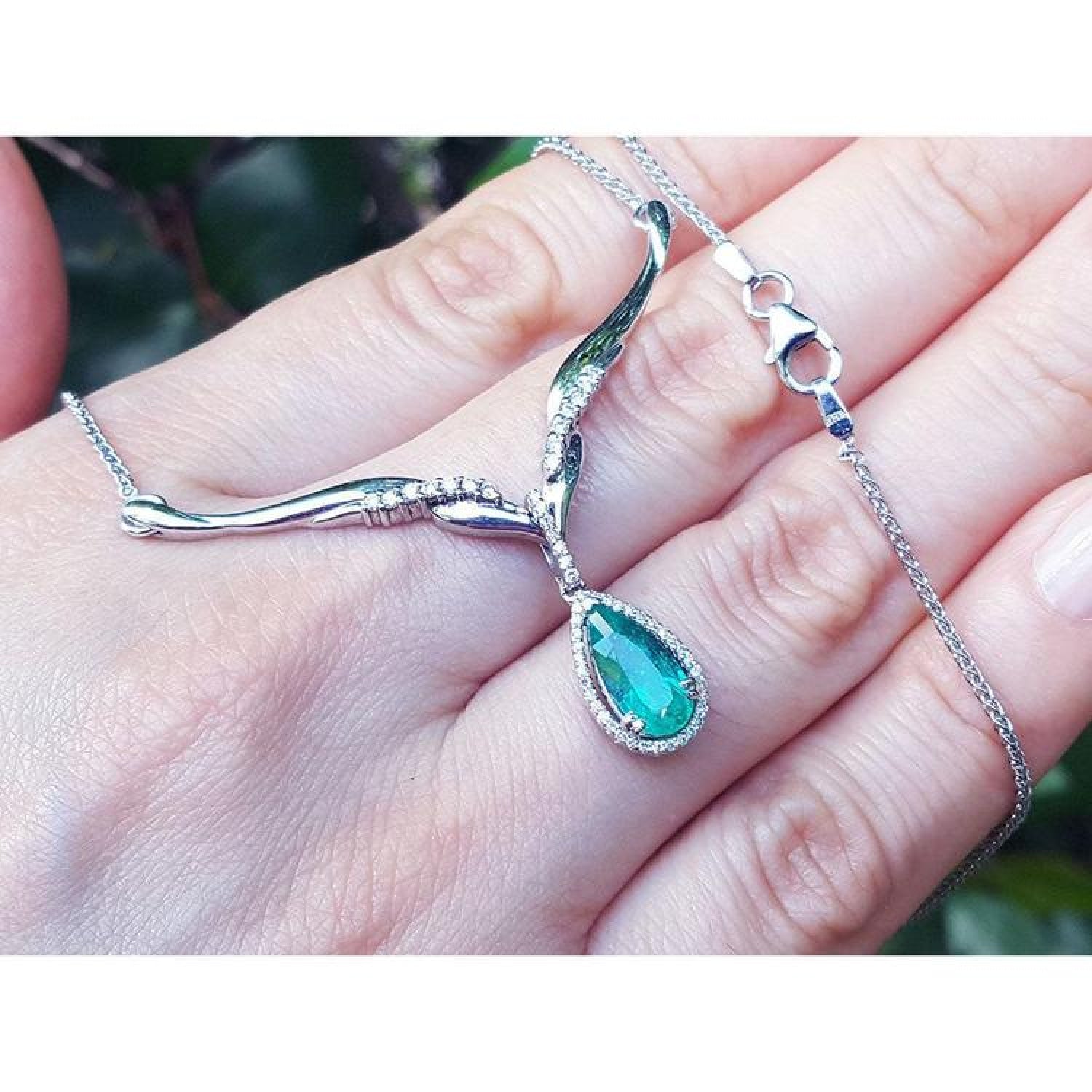 1.28 carat pear cut emerald necklace in 14K white gold with diamonds and chevron design.