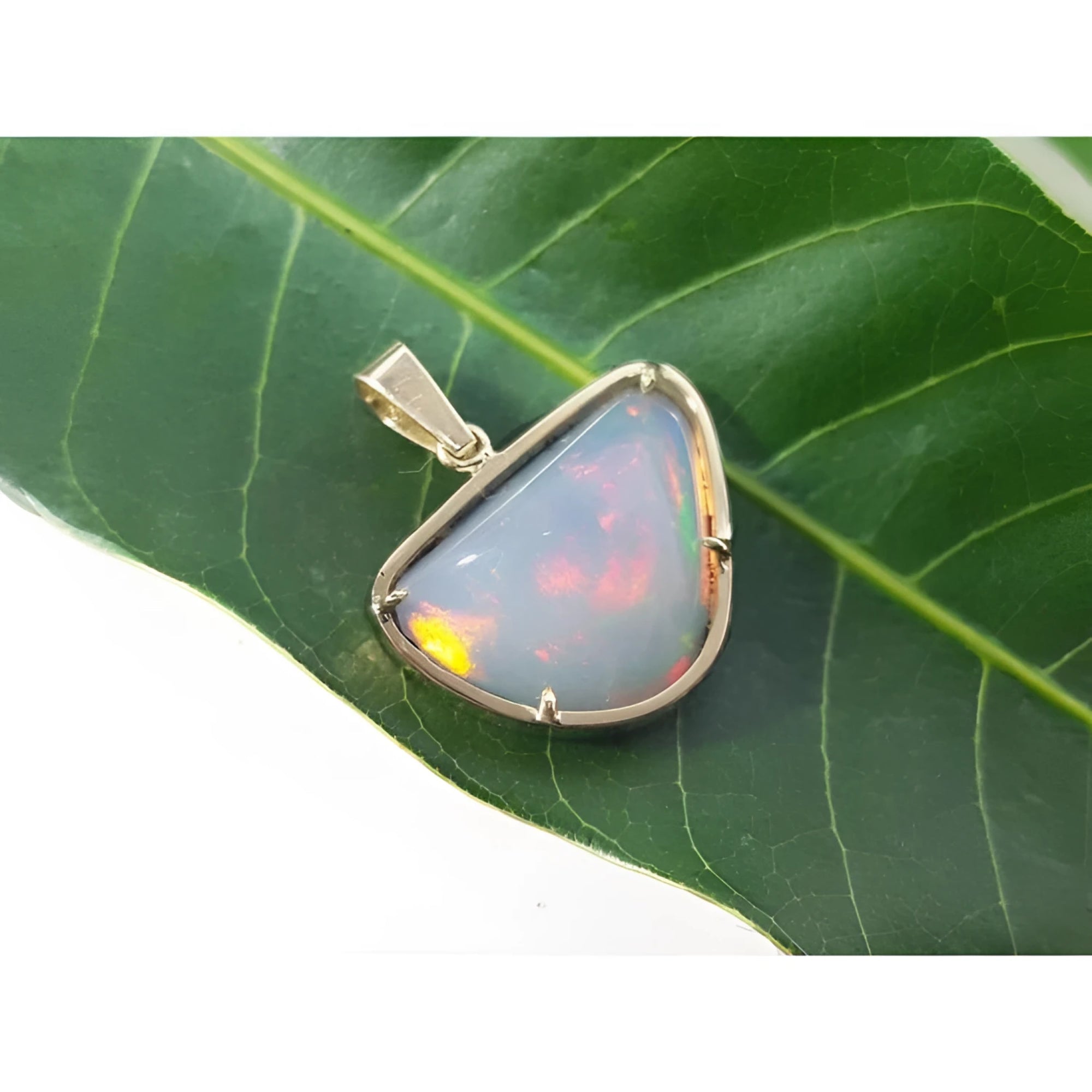 9.30 ct. Ethiopian opal necklace pendant in 14K yellow gold, showcasing vibrant red and orange fire.