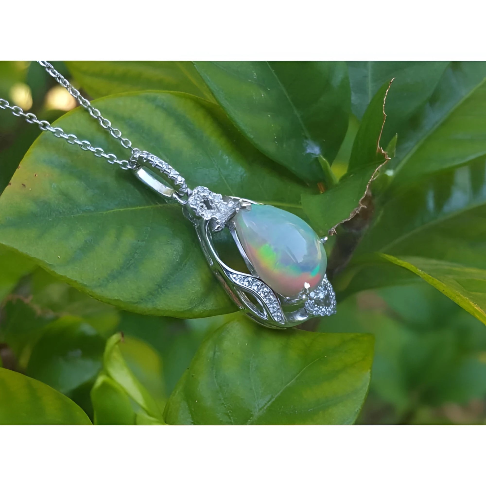Pear-shaped rainbow Welo Ethiopian opal pendant in 925 sterling silver with cubic zirconia accents.