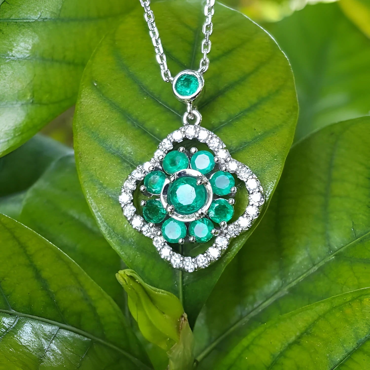 14K white gold cluster necklace with natural Colombian emeralds and diamond 4-leaf clover design on green leaves.