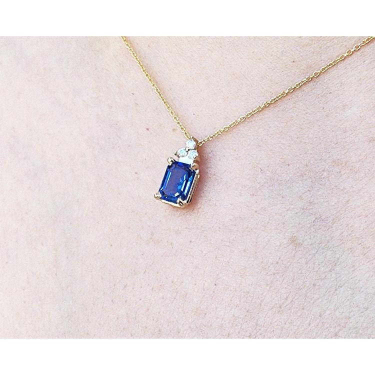 14k gold necklace with a rectangular blue sapphire pendant and three accent diamonds.