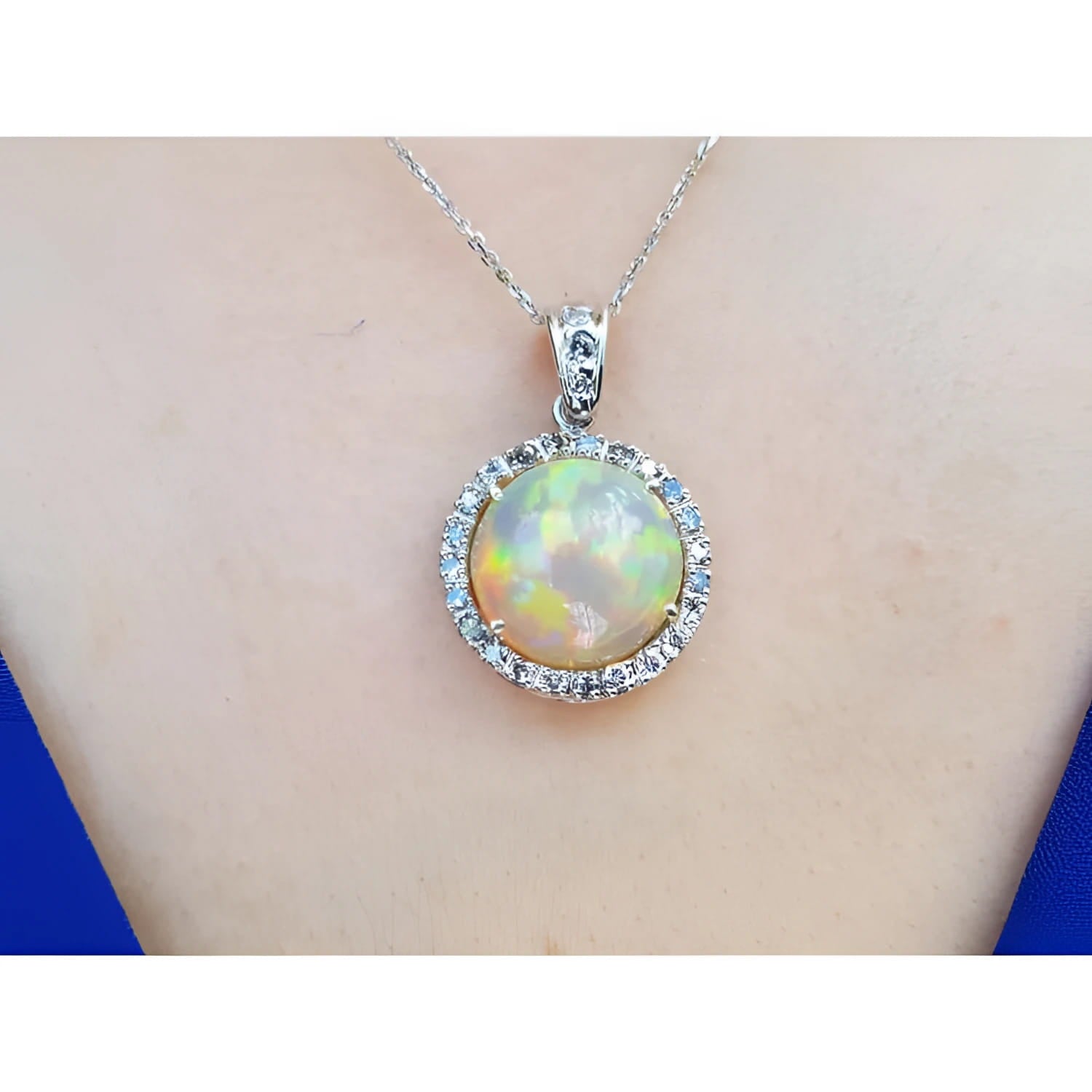 Ethiopian Welo opal and diamond pendant in 14K white gold, featuring a round opal with red flashes.