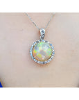 Ethiopian Welo opal and diamond pendant in 14K white gold, featuring a round opal with red flashes.