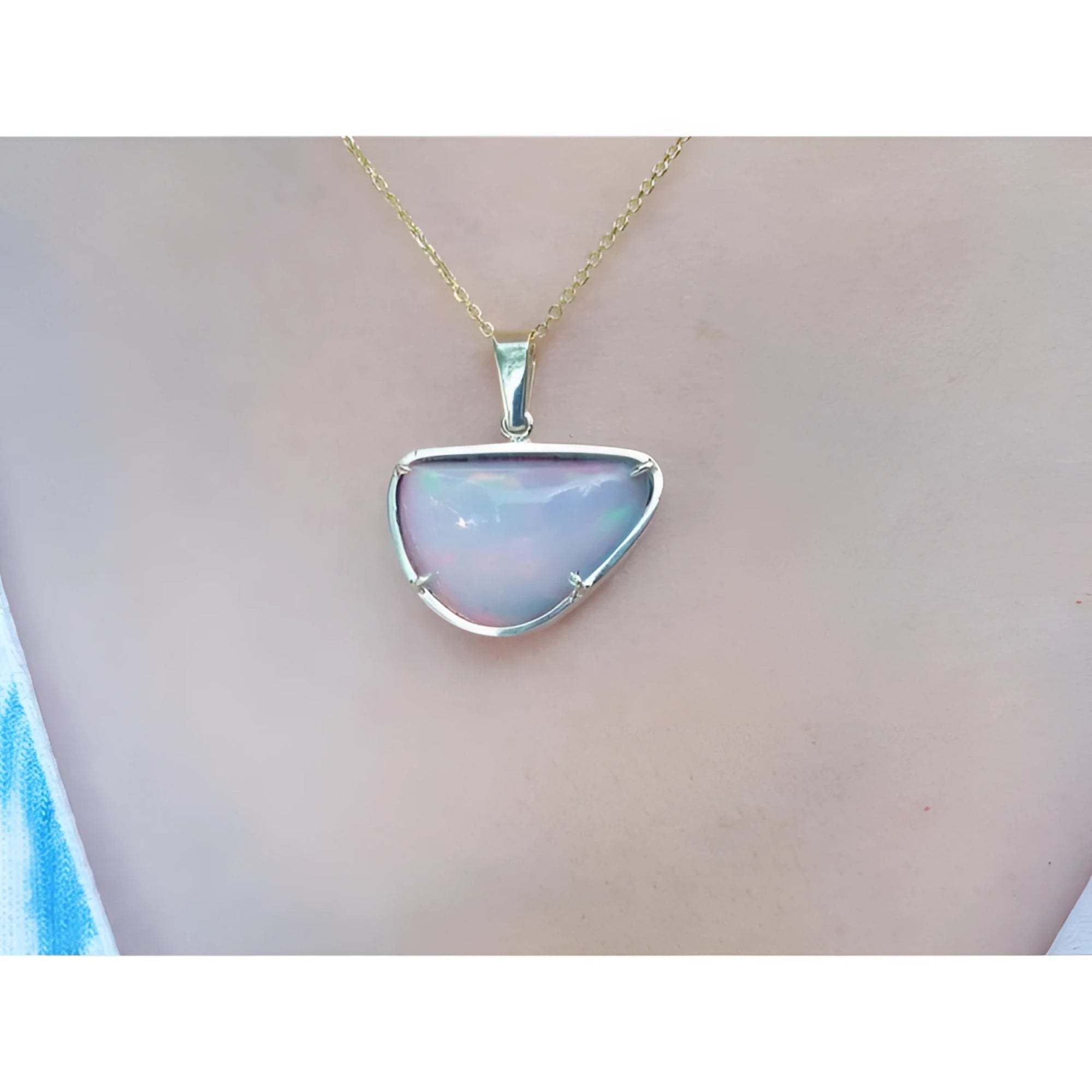 Ethiopian opal necklace pendant with red/orange fire, free-form cabochon, 14K yellow gold setting.