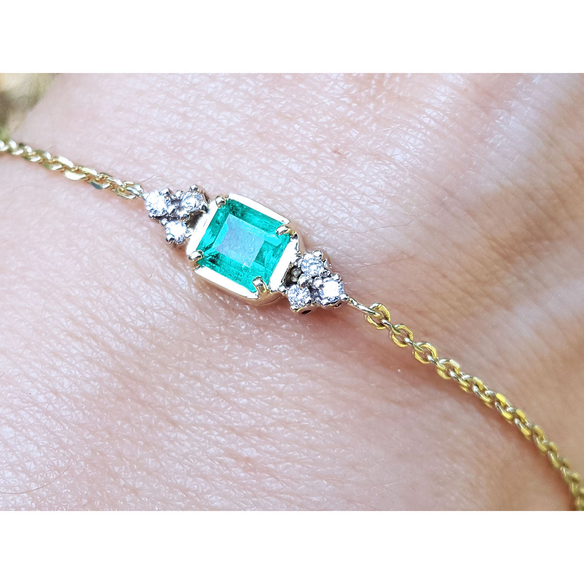 Gold bracelet for women 0.85 carat natural emerald side diamonds accent yellow gold 14k on a wrist.