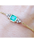 Gold bracelet for women 0.85 carat natural emerald side diamonds accent yellow gold 14k on a wrist.