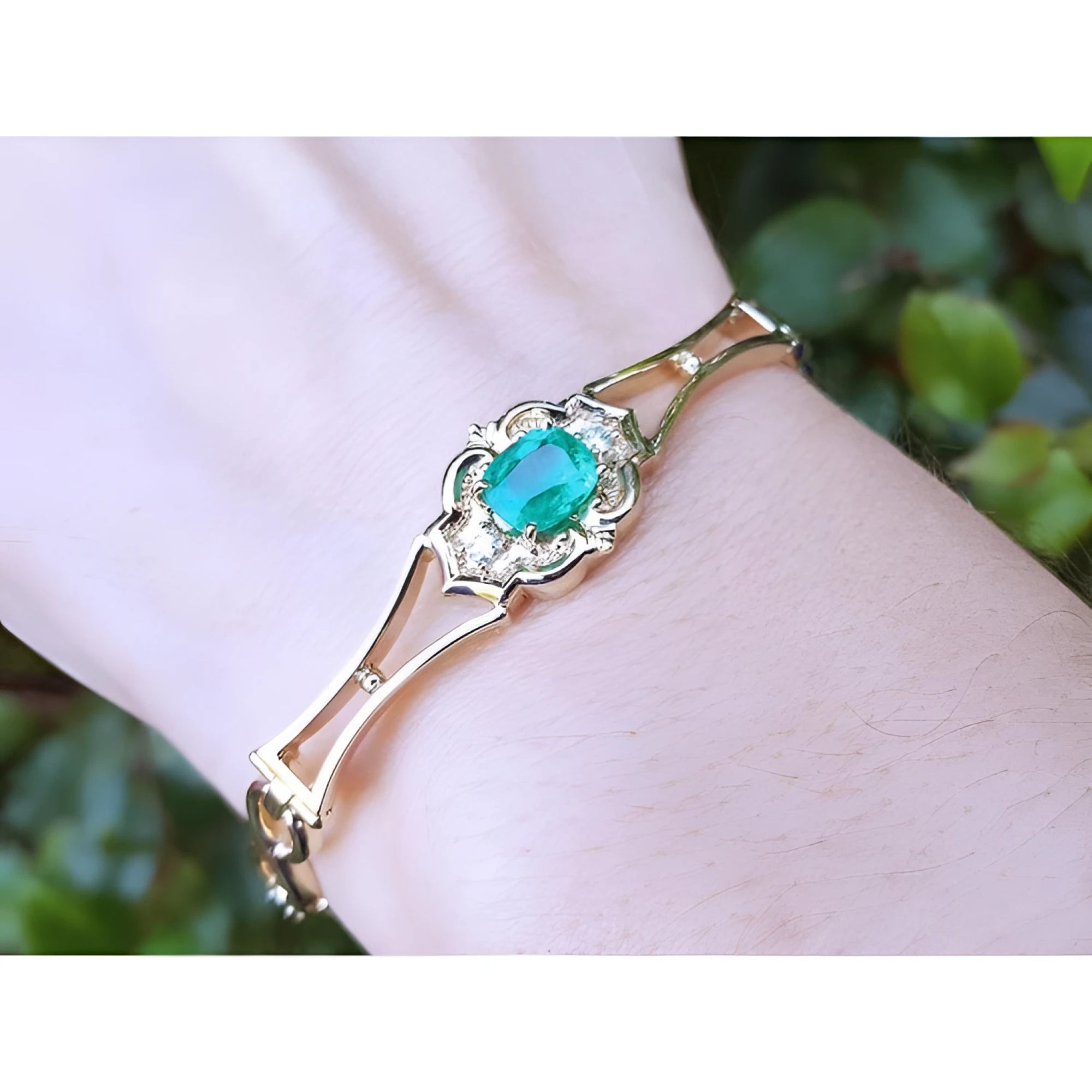 14K yellow gold women's bracelet with a central oval-cut natural emerald and sparkling accents.