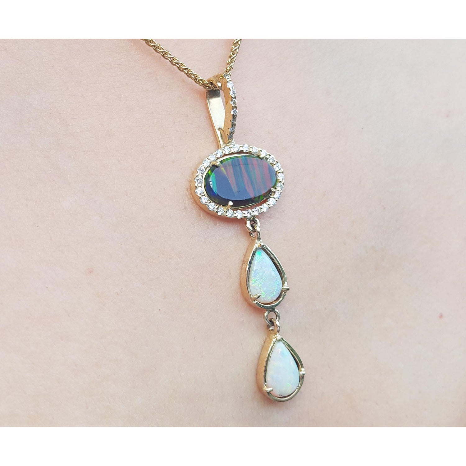 Opal pendant necklace on a person&#39;s neck with a plain skin background.