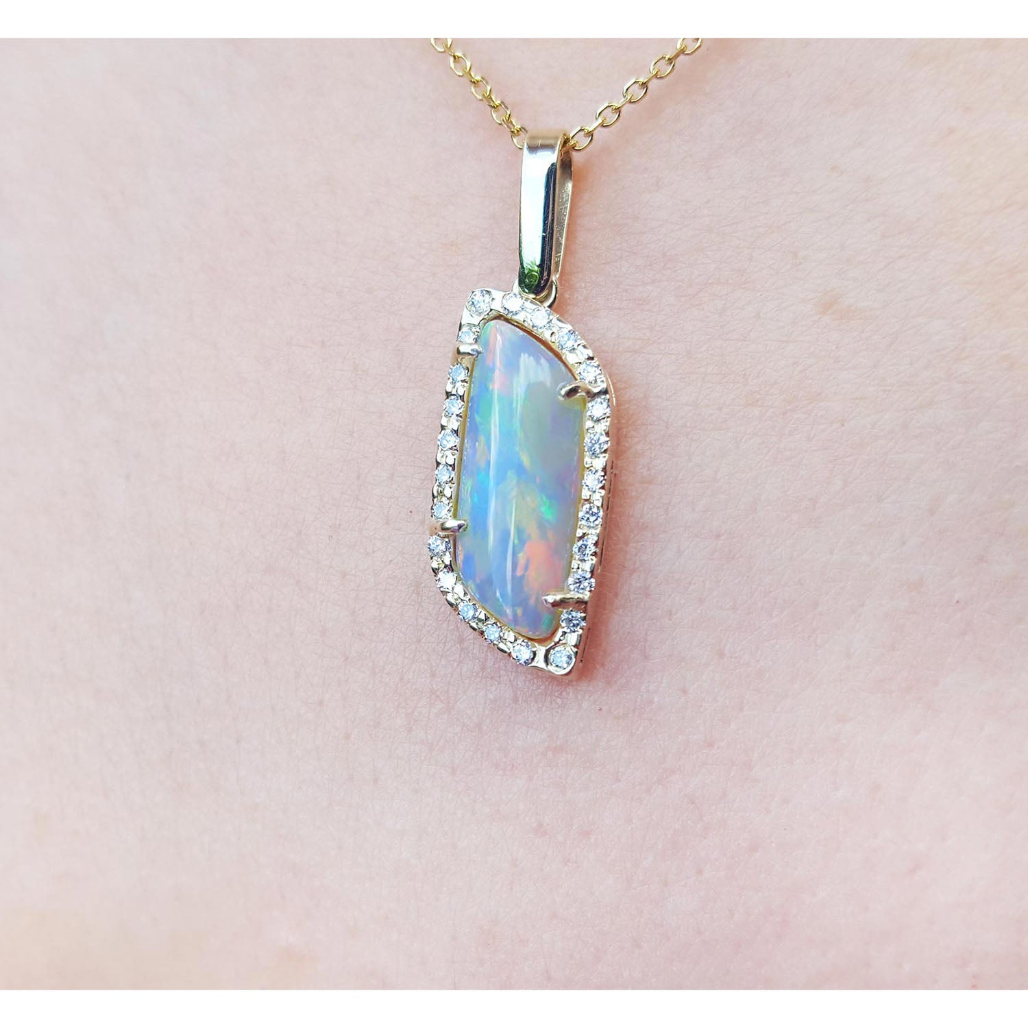 Opal pendant necklace on a pink background