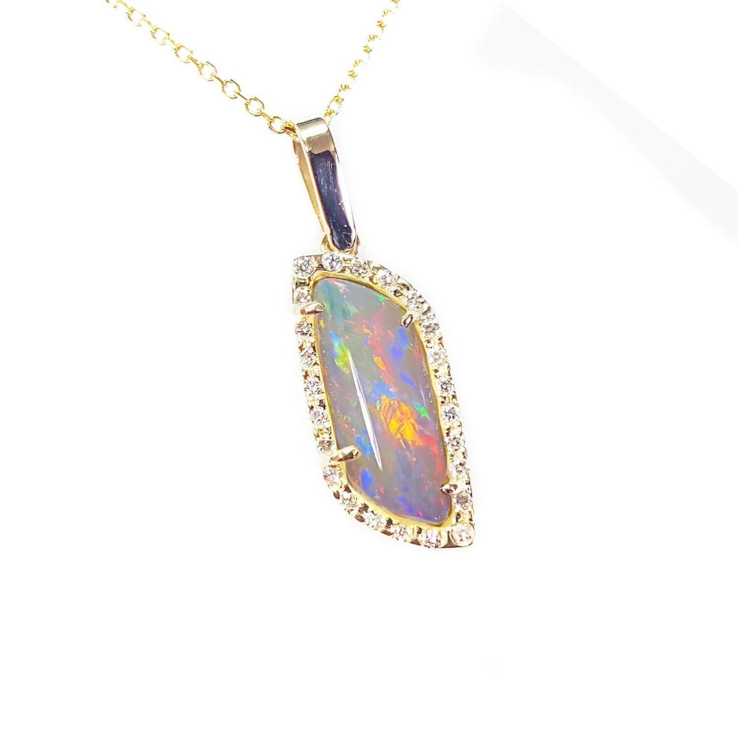 Opal pendant necklace with gold chain on a topside view