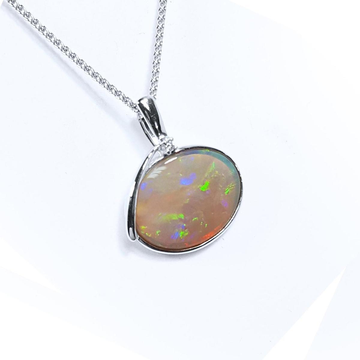 A natural Australian opal pendant necklace on a white background