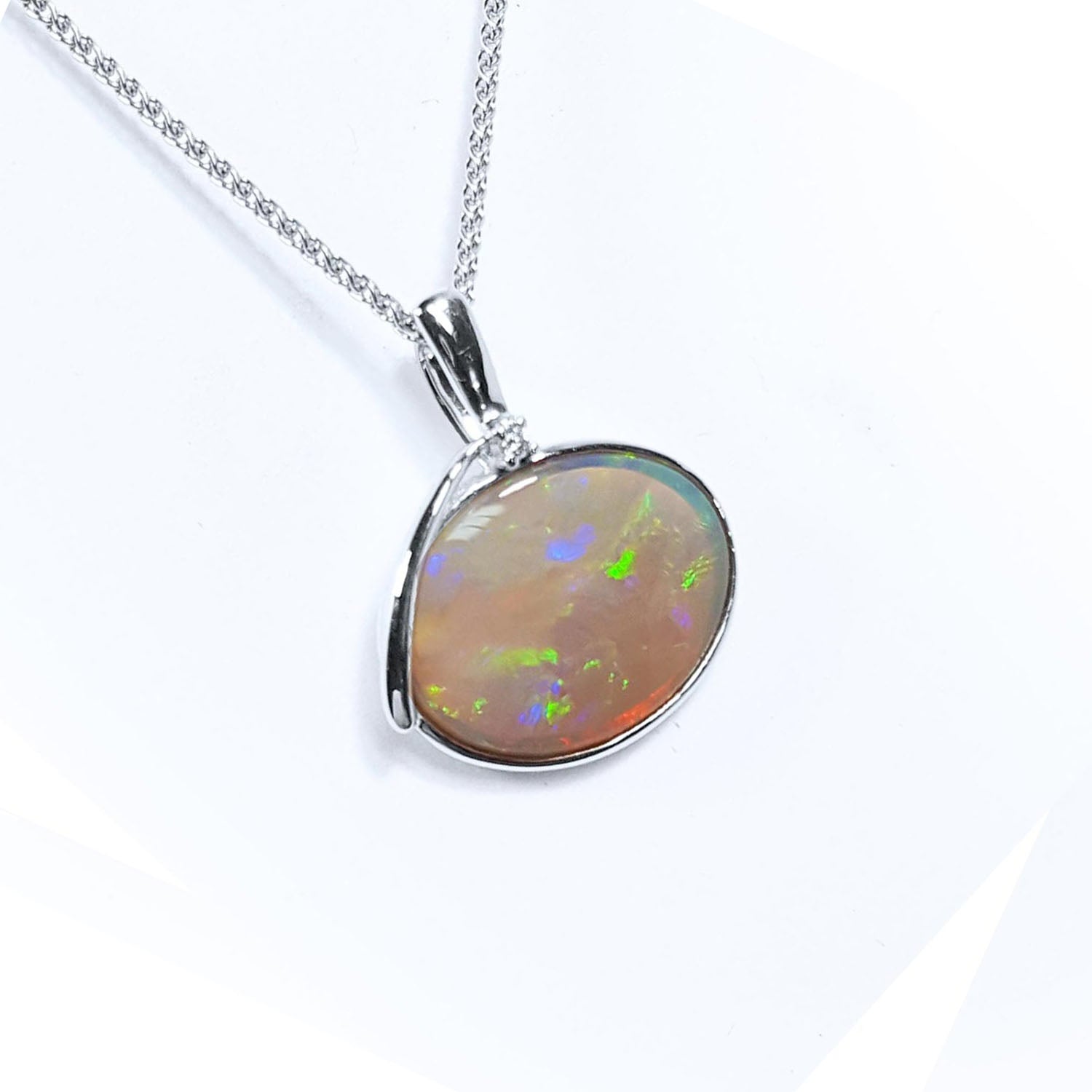 A natural Australian opal pendant necklace on a white background