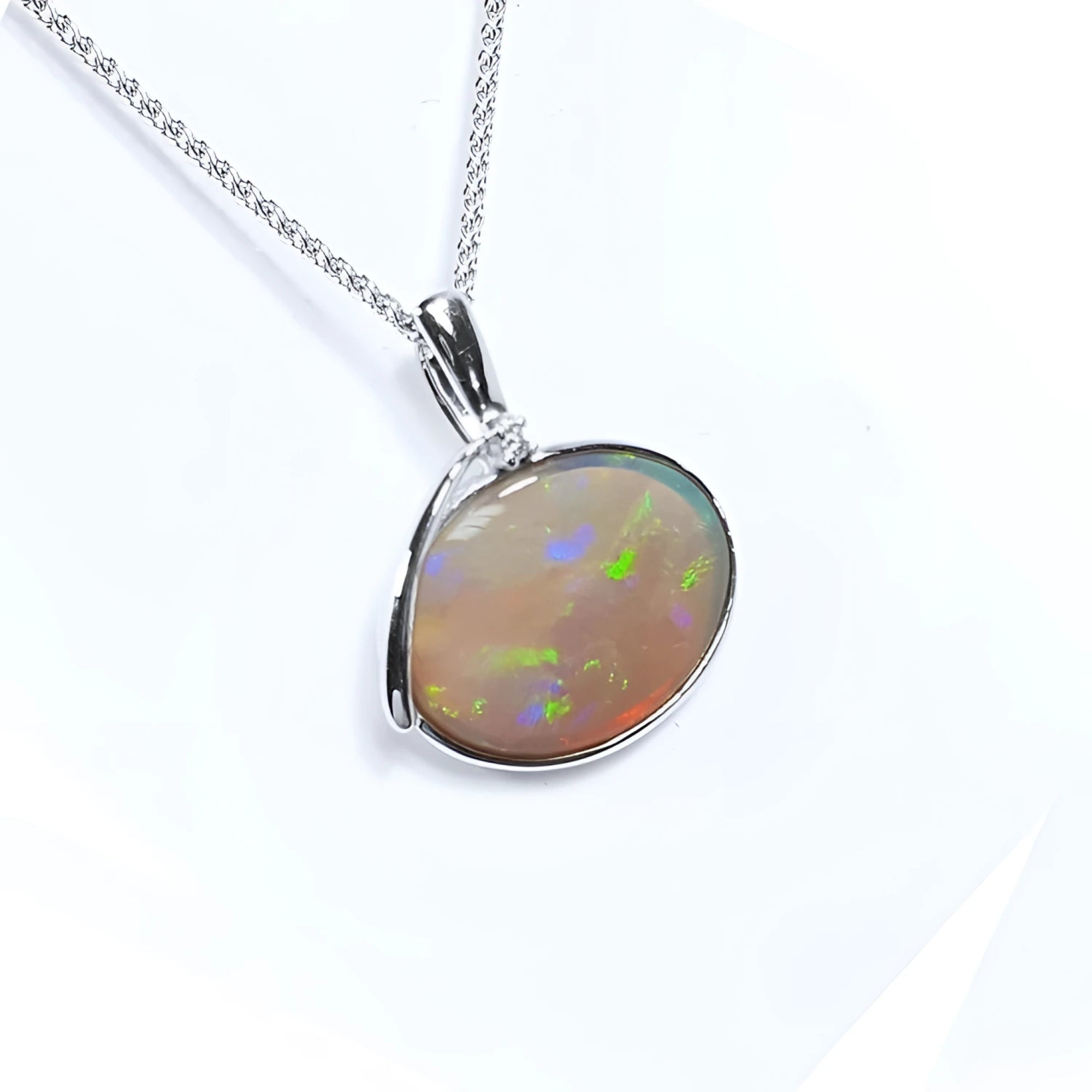 2.25 ct Australian opal pendant in 14K white gold, east-west bezel set, with bluish-green flashes.