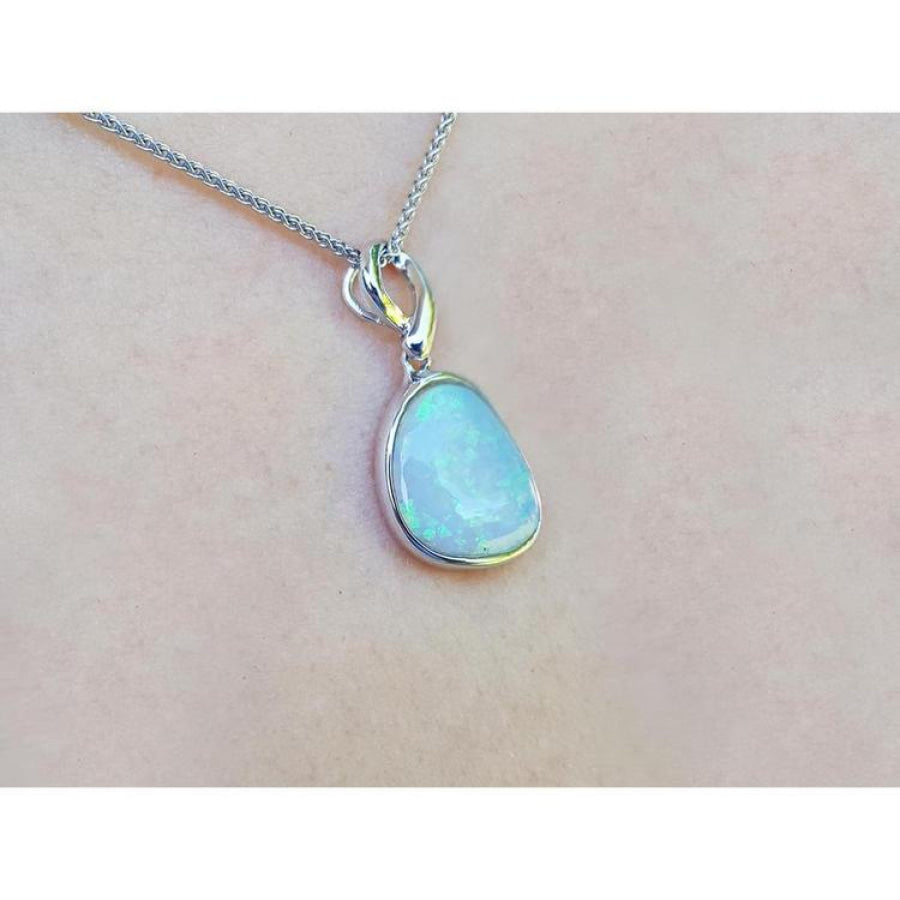 Freeform bluish-green Australian opal pendant, bezel set in 14K white gold on a chain.