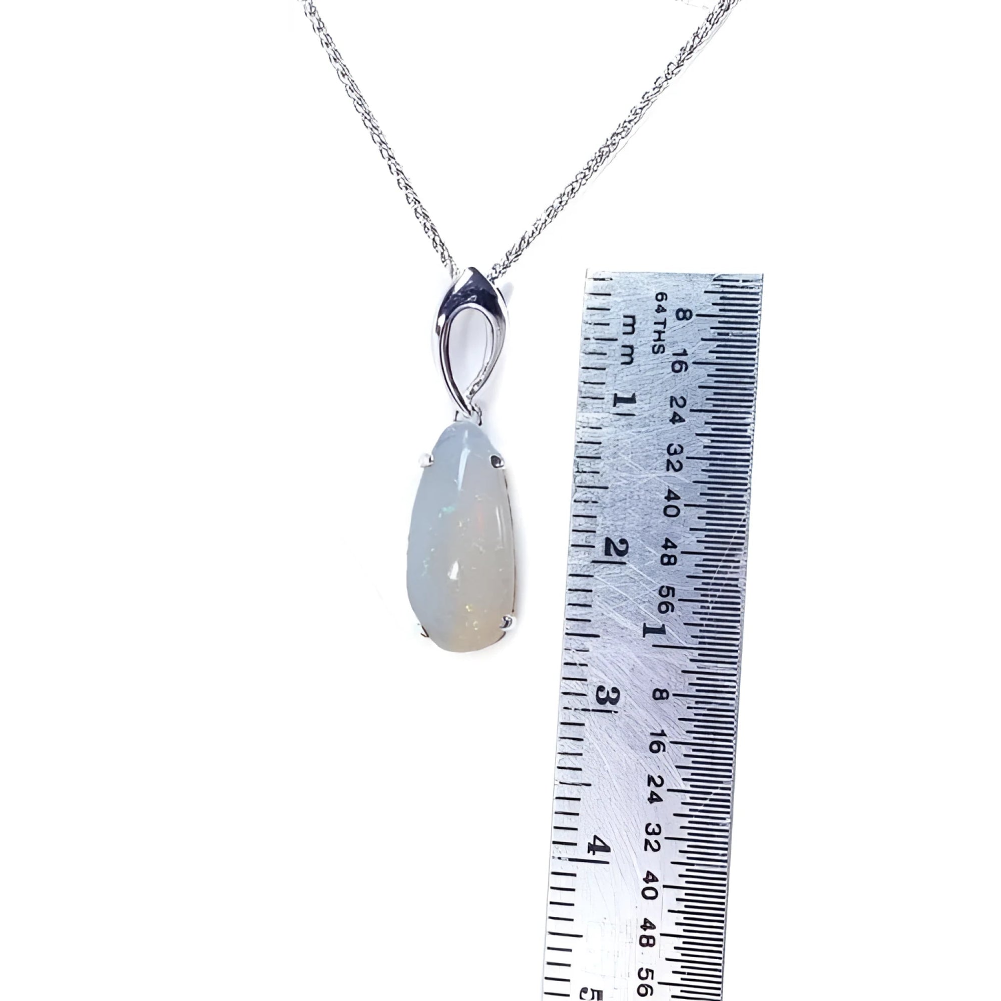 Pear-shaped 2.12 ct white opal solitaire pendant in 14K white gold, shown with a ruler.