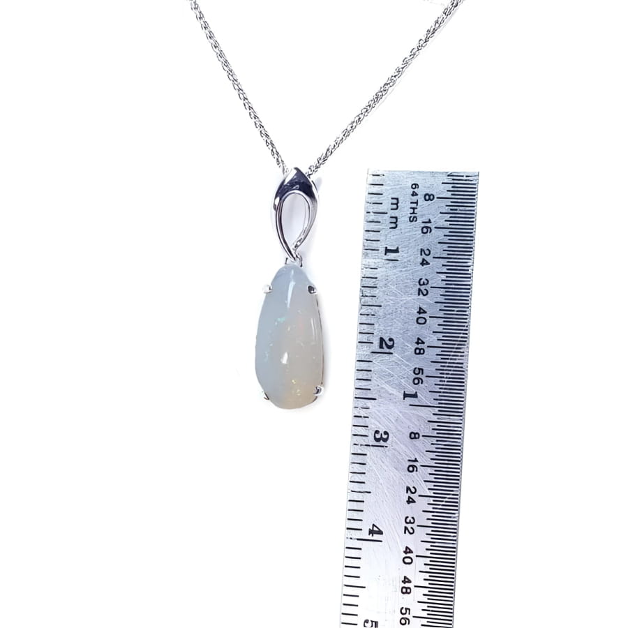 Pear-shaped 2.12 ct white opal solitaire pendant in 14K white gold, shown with a ruler.