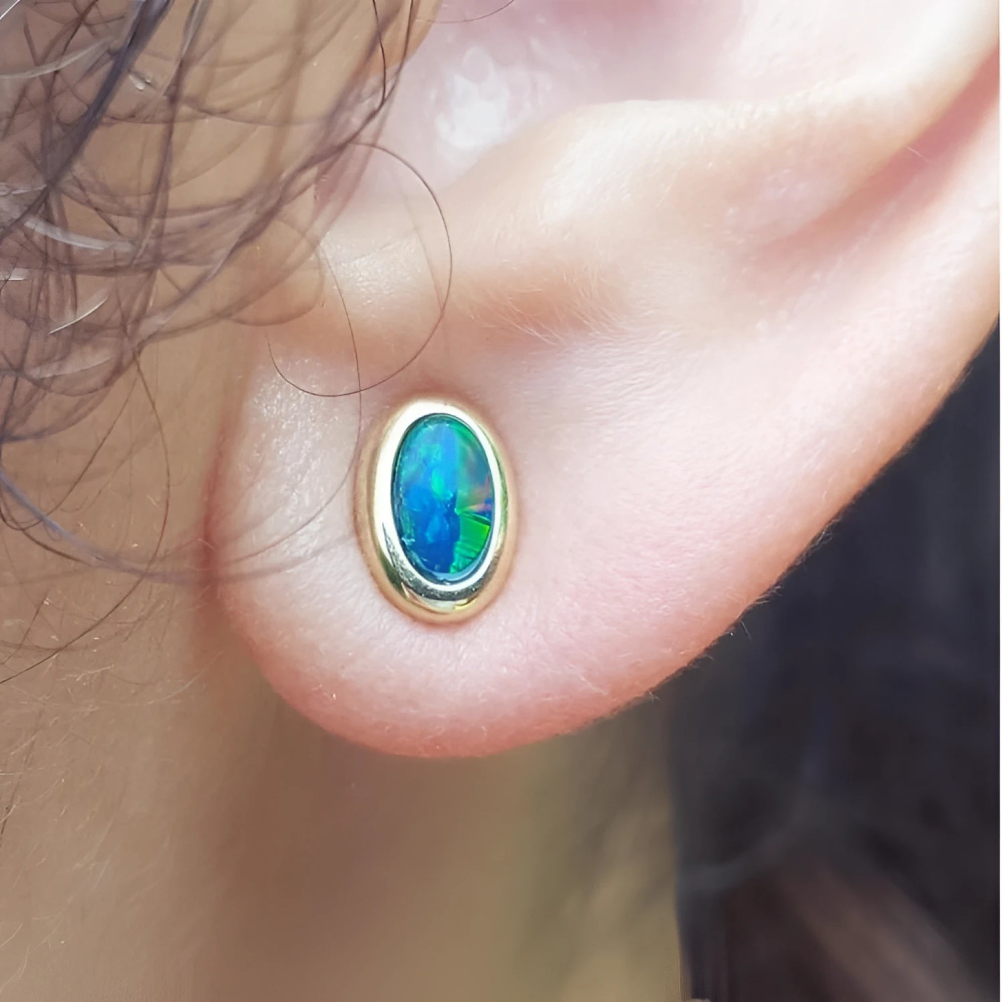 14k yellow gold oval stud earrings with sparkling blue Australian opal doublets, bezel set.
