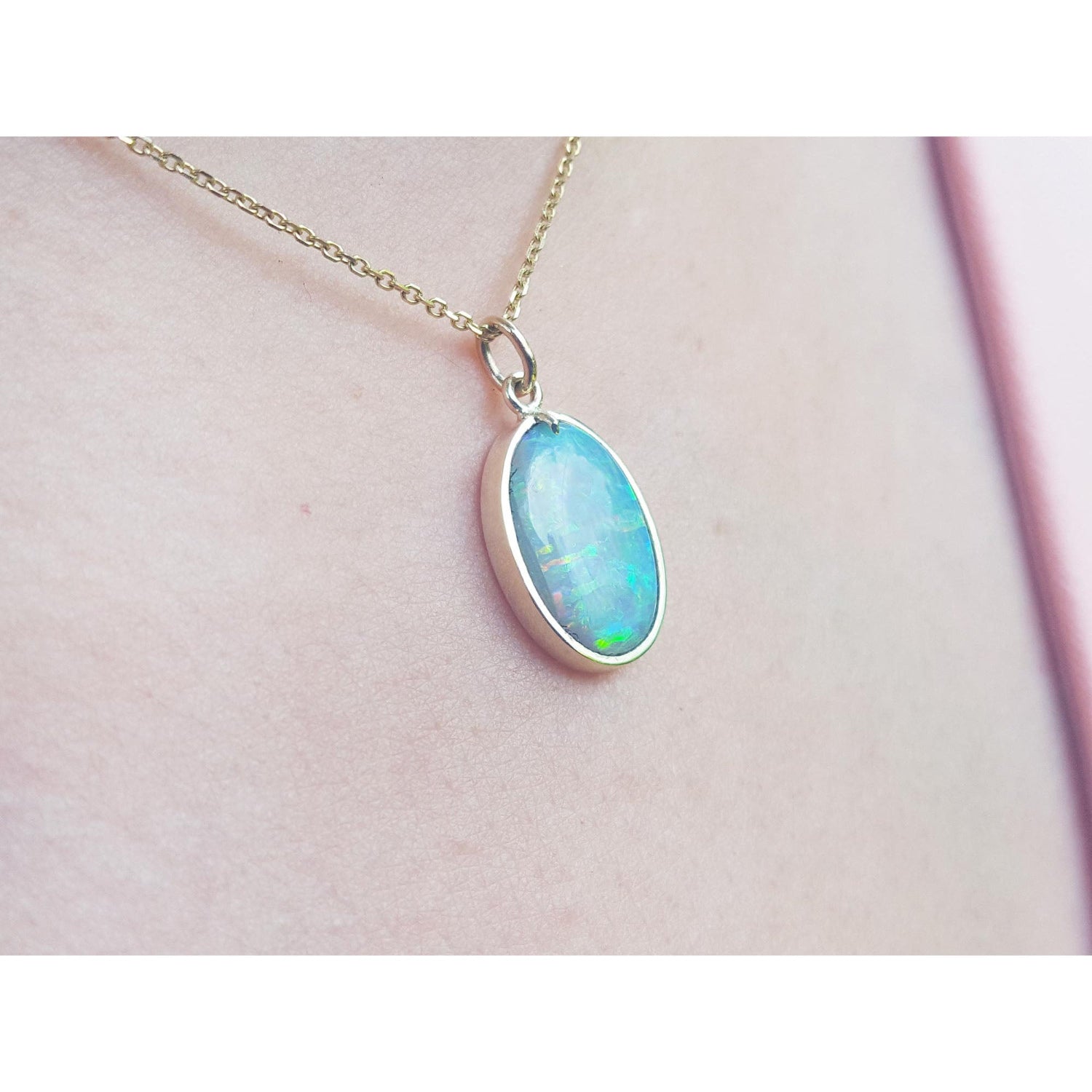 Necklace with a teardrop-shaped opal pendant on a person&#39;s neck.