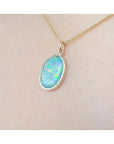 Opal pendant necklace on a beige skin background