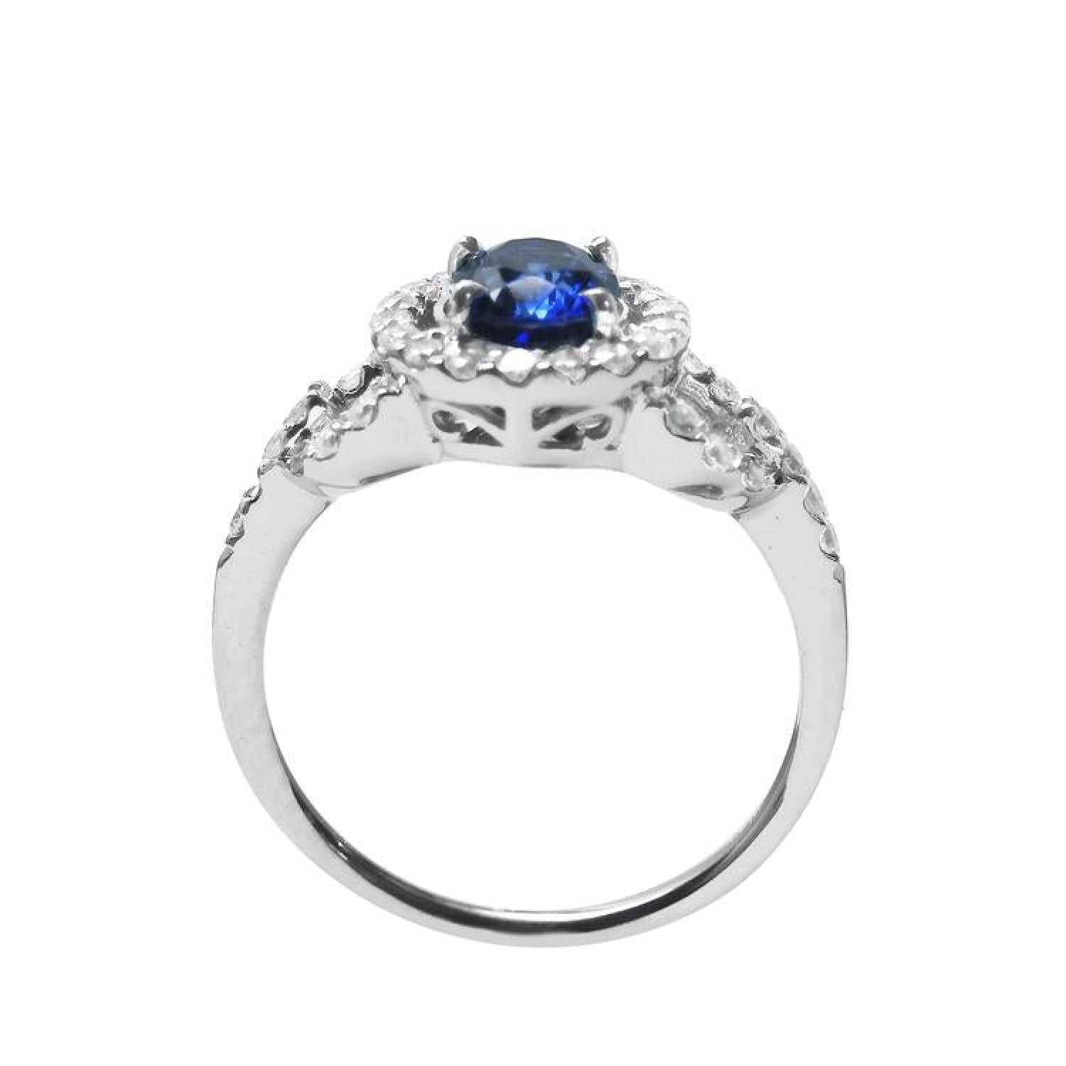 1.08 ct oval blue sapphire ring in 14K white gold with diamond halo and pavé band.