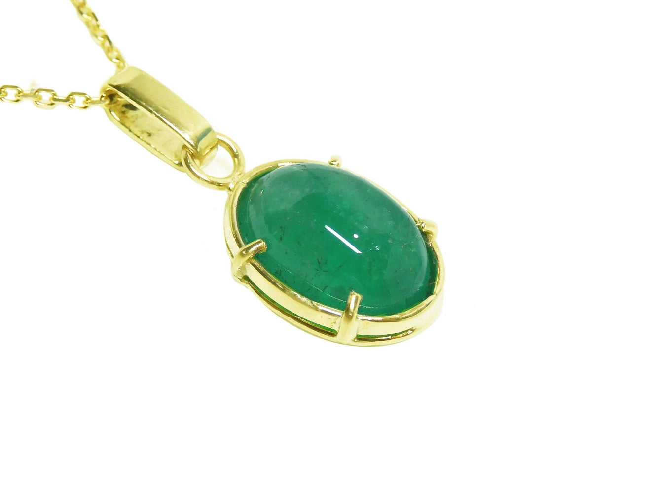 Gold pendant with an oval cabochon emerald pendant right ide profile view.
