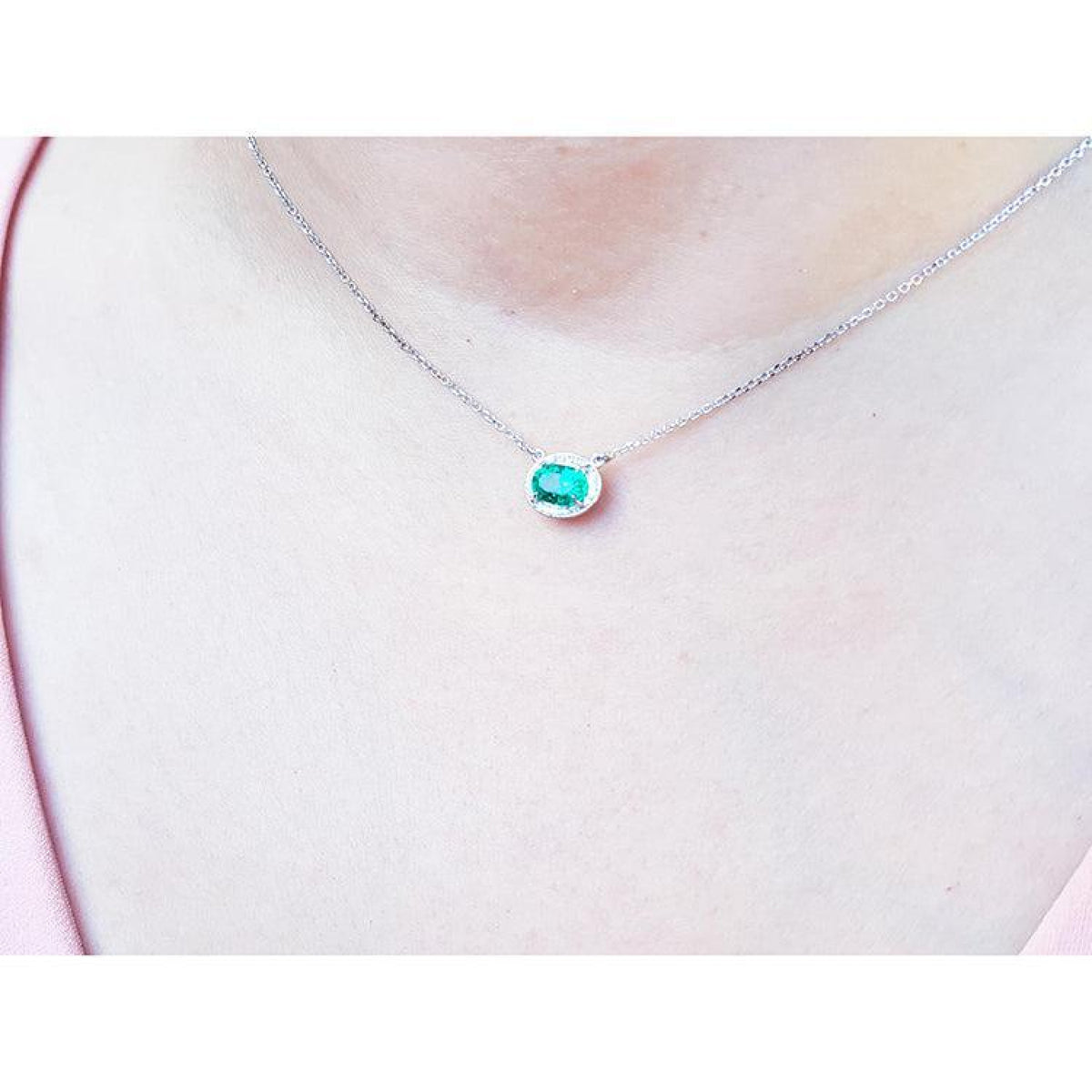 Oval 1.00 ct. emerald necklace with diamond halo, east-west, on a 14K white gold chain.