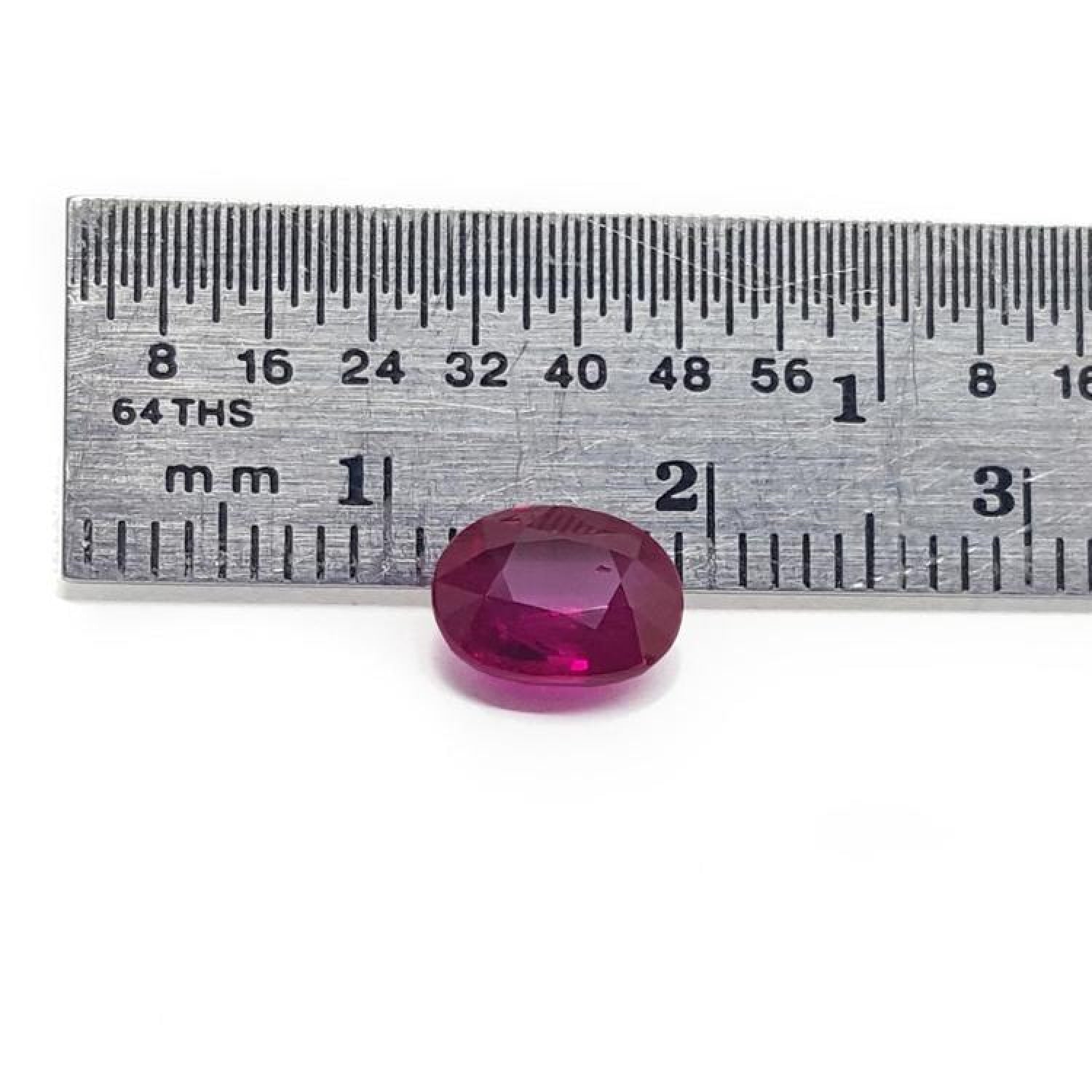 1.59 carat natural Burma ruby, oval cut, medium deep red, displayed next to a ruler.