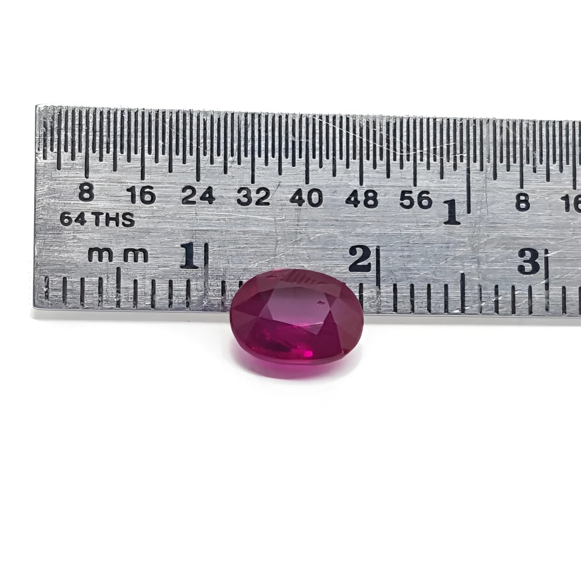 1.59 carat natural Burma ruby, oval cut, medium deep red, displayed next to a ruler.