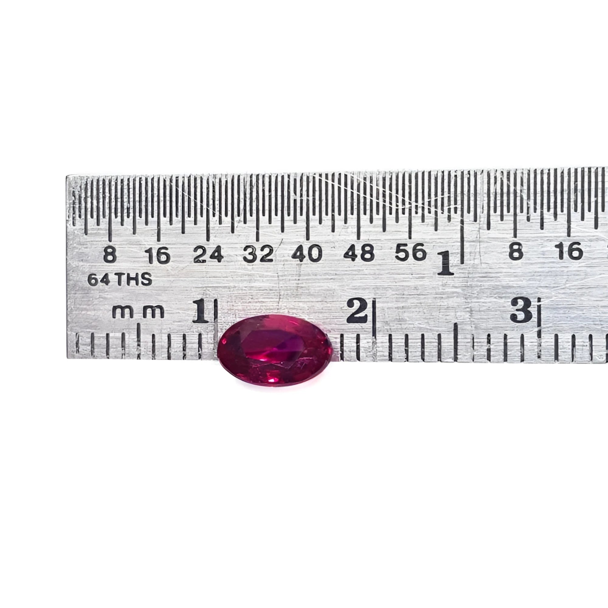 0.91 carat oval cut natural Burmese ruby with a vibrant medium deep red hue, shown next to a ruler.