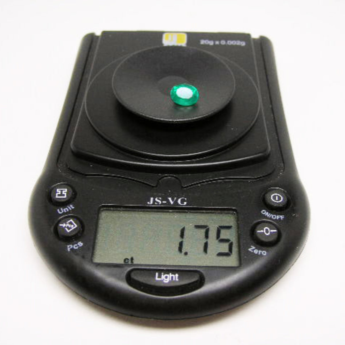 Oval cut loose natural colombian emerald on digital pocket scale showing weight