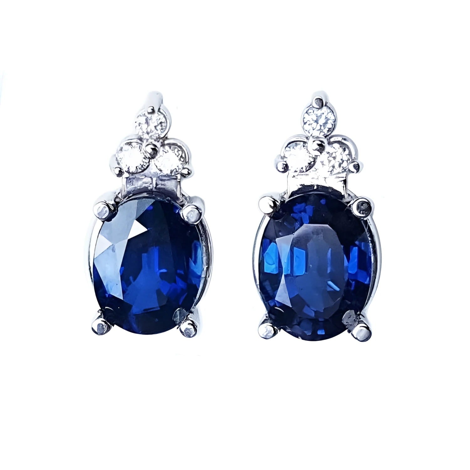 Natural blue sapphire earrings oval cut stud diamonds white gold, topped with three prong-set natural diamonds.
