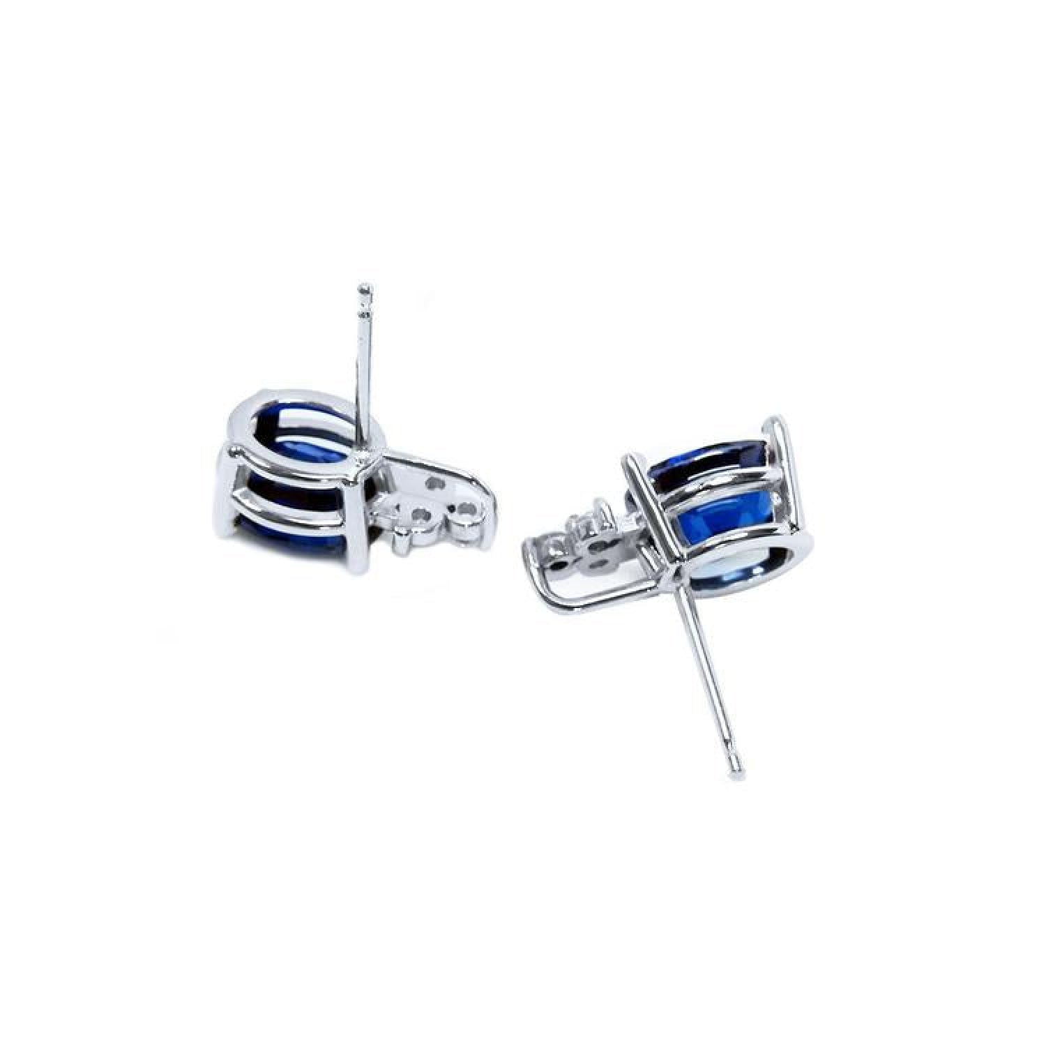 Oval natural blue sapphire stud earrings in 14K white gold with diamond accents.